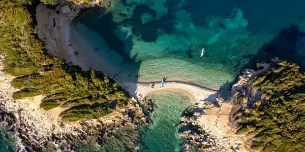 DDD Invoices supports fiscalisation in Albania, with a scenic coastal harbor featuring boats, turquoise waters, and hillside city views. 