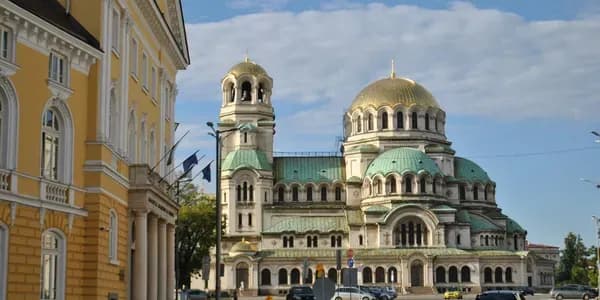 Vibrant cityscape of Sofia, Bulgaria, with colorful buildings, parks, and mountain views, showcasing the modernization of business processes supported by DDD Invoices’ e-invoicing solutions in Bulgaria.