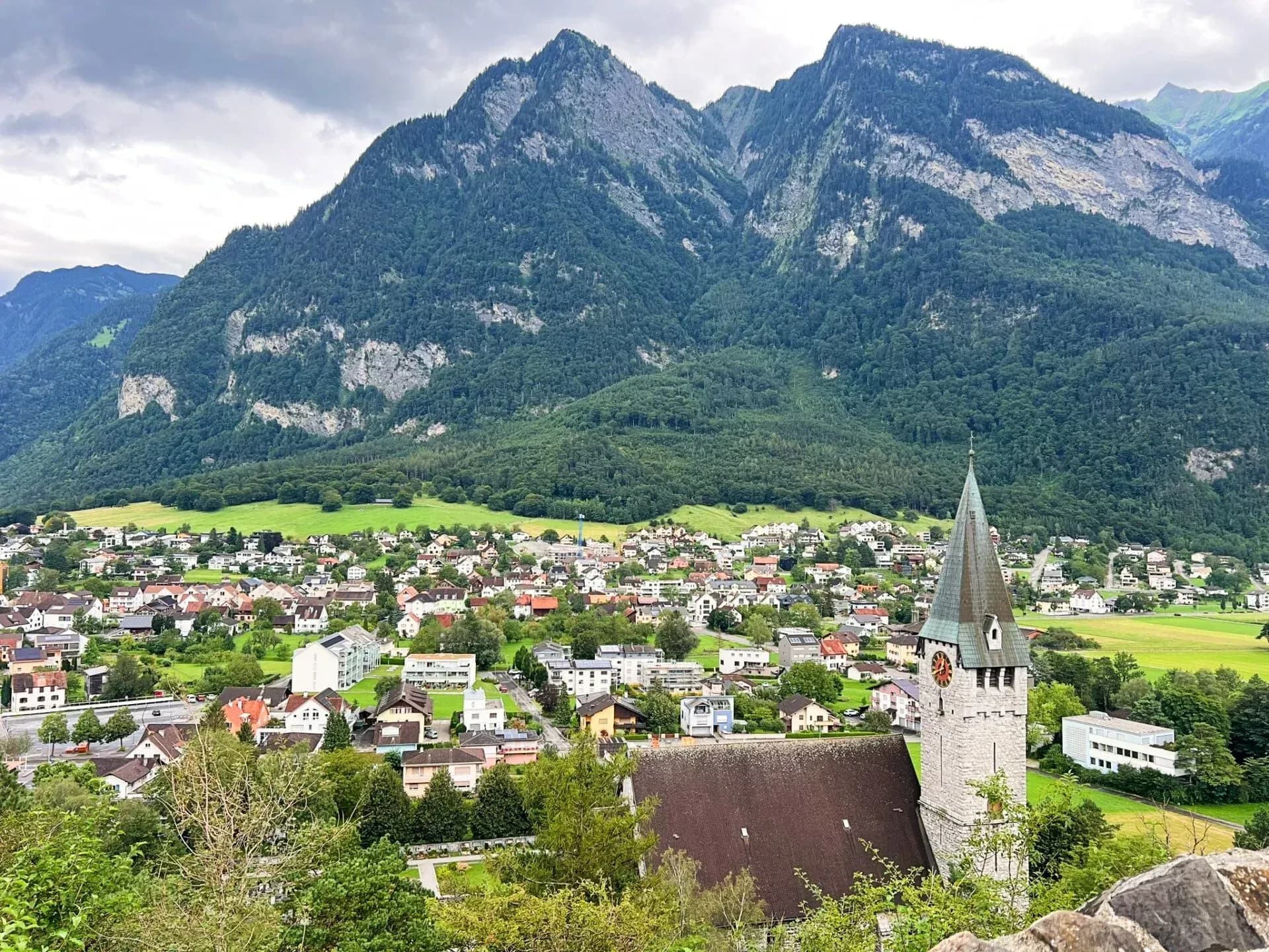 DDD Invoices supporting fiscalisation in Liechtenstein, featuring Vaduz with a church tower, alpine village houses, and forested mountains in the background.