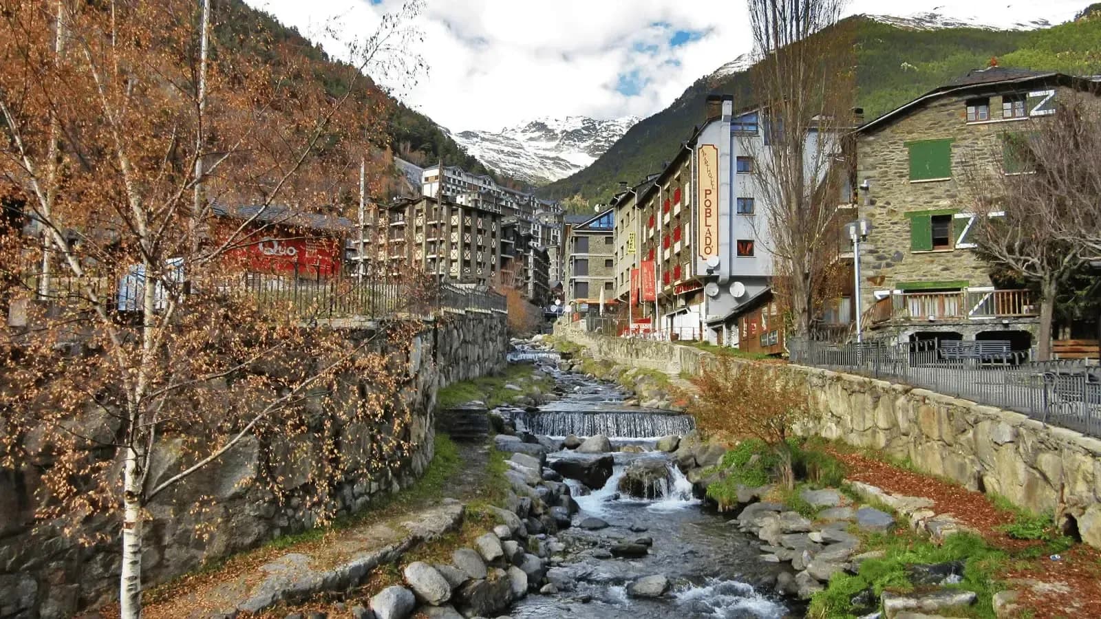 DDD Invoices supporting fiscalisation in Andorra, with a scenic mountain village view featuring a small river, stone buildings, and alpine surroundings.