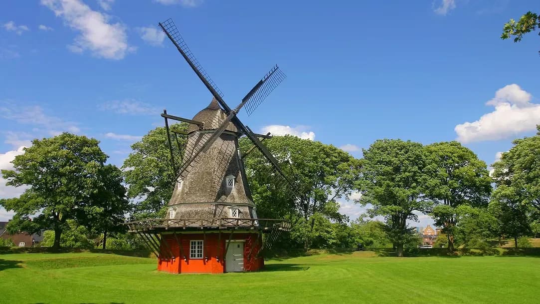 DDD Invoices supporting fiscalisation in Denmark, with a traditional windmill set in a green park landscape under a clear blue sky.