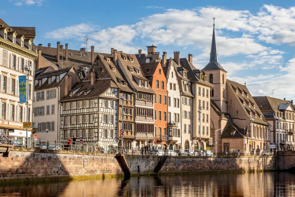 DDD Invoices supporting e-invoicing in France, featuring Strasbourg’s riverside with colorful half-timbered houses, a church spire, and reflections in the water.
