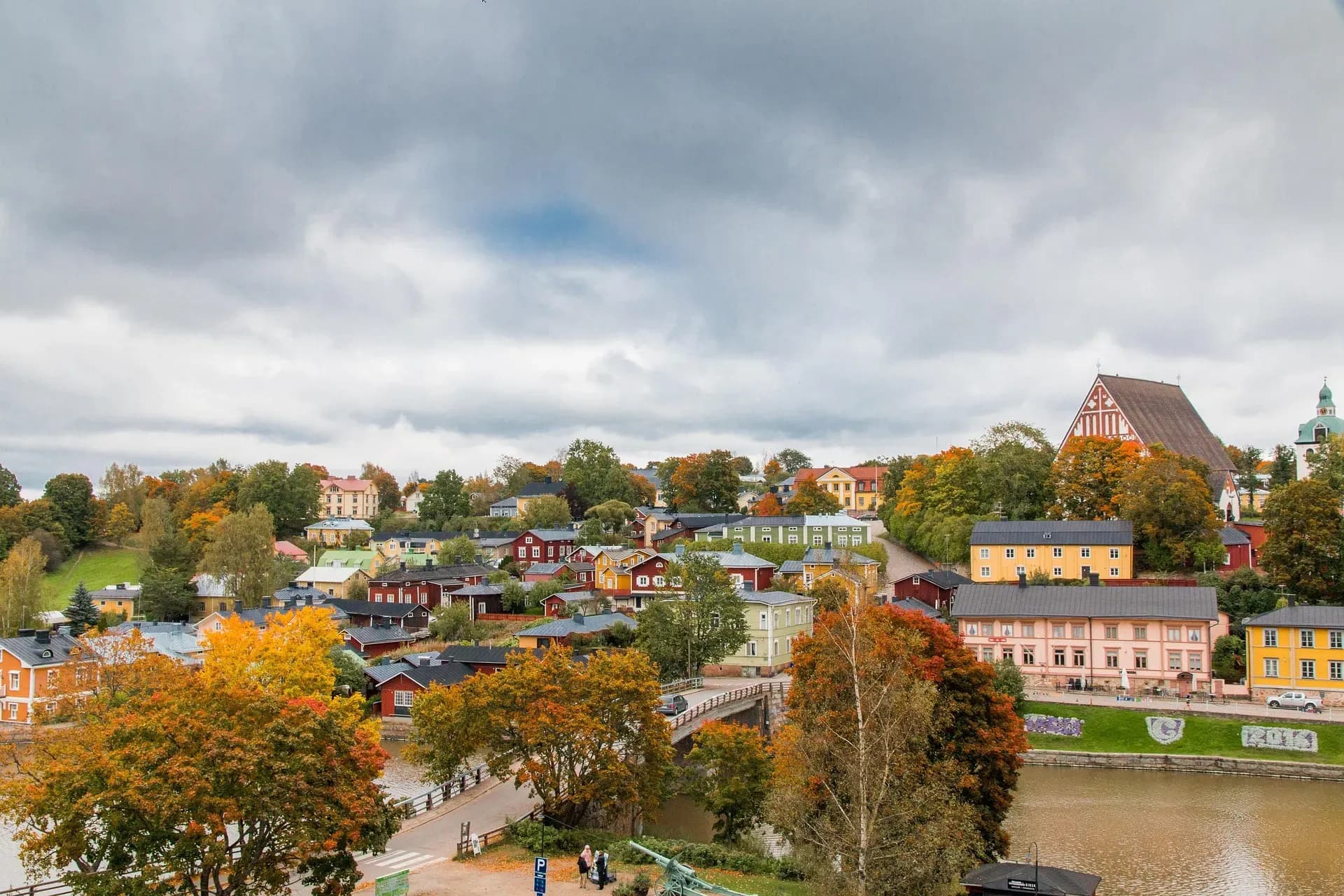 DDD Invoices supporting e-invoicing in Finland, featuring a colorful autumn townscape with historic buildings, a river, and a large cathedral under a cloudy sky.