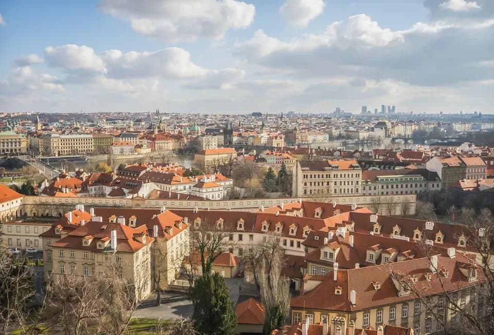 Panoramic view of Prague’s historic cityscape with red-roofed buildings, church towers, and bridges across the Vltava River, used by DDD Invoice in an article about e-invoicing and fiscalization developments in the Czech Republic.