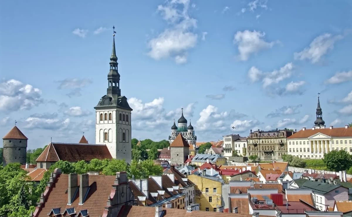 DDD Invoices supporting e-invoicing in Estonia, featuring Tallinn’s old town skyline with medieval towers, colorful rooftops, and church spires under a bright blue sky.