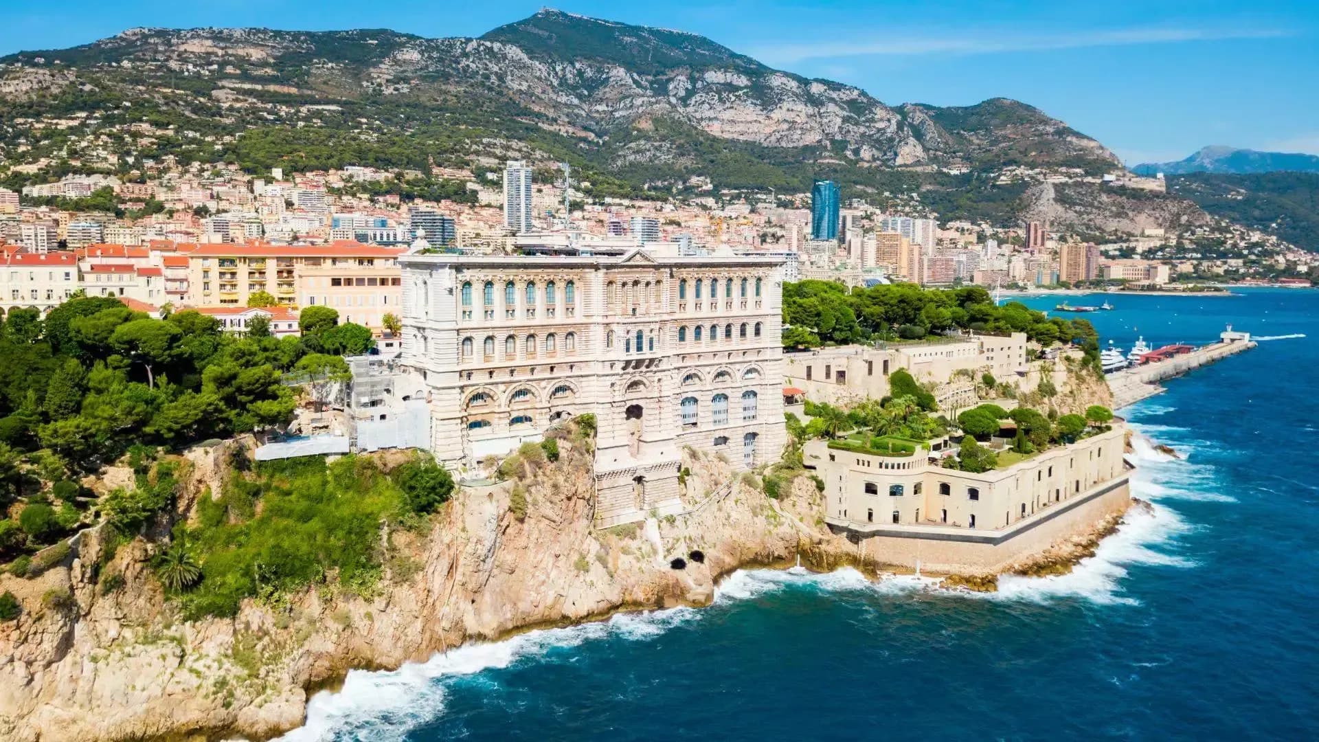 DDD Invoices supporting fiscalisation in Monaco, featuring the Oceanographic Museum on a cliff overlooking the Mediterranean and the Monte Carlo coastline.