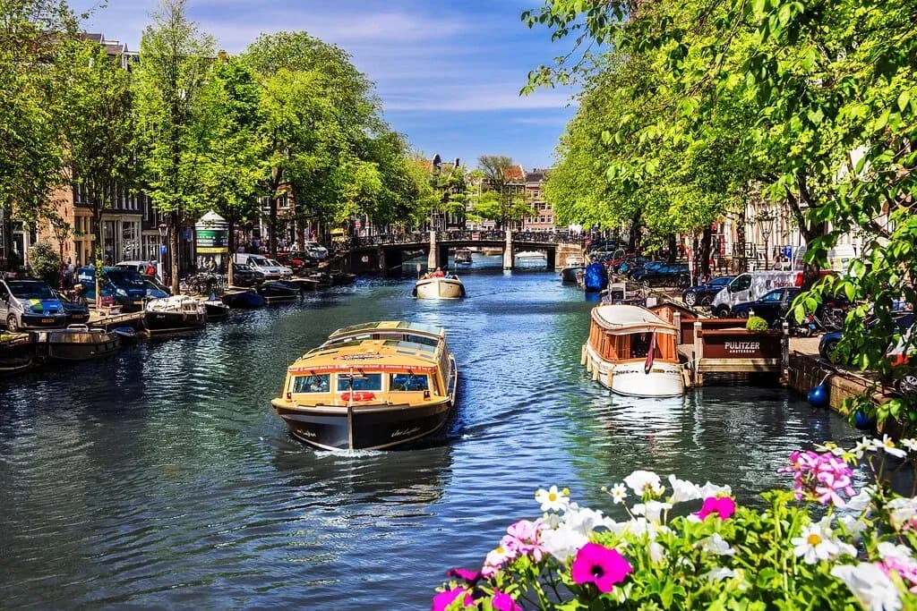DDD Invoices supporting fiscalisation in the Netherlands, with a canal view in Amsterdam, boats, tree-lined streets, and historic bridges.