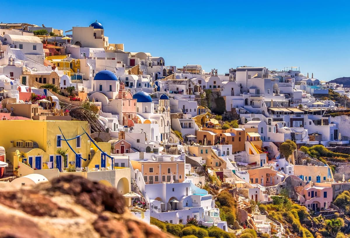DDD Invoices supporting e-invoicing in Greece, featuring Santorini’s hillside of white buildings with blue domes under a clear sky.