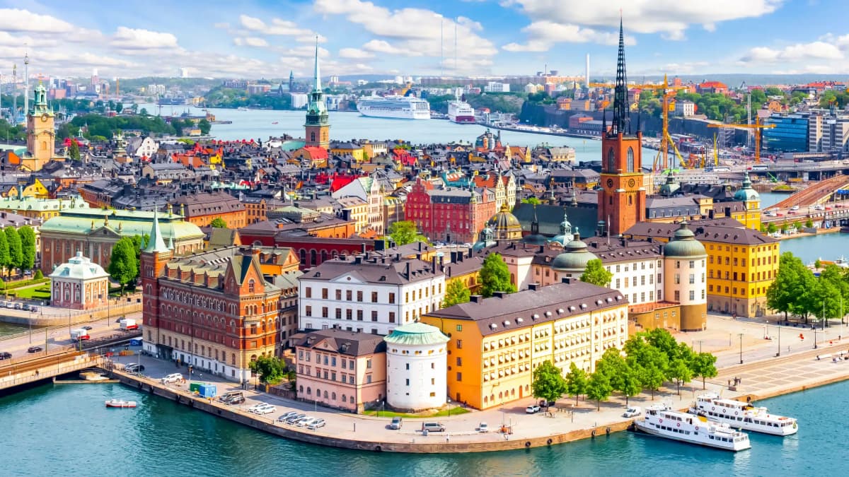DDD Invoices supporting fiscalisation in Sweden, with a panoramic view of Stockholm’s historic waterfront, colorful buildings, and church spires along the Baltic Sea.