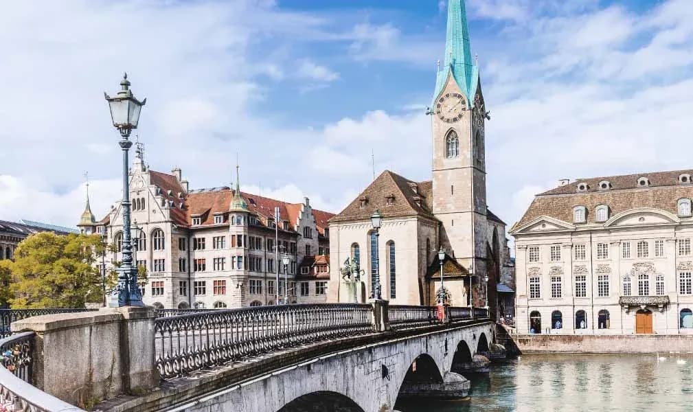 View of Zurich’s historic old town with a stone bridge and church tower, illustrating Switzerland’s fiscalisation and e-reporting, supported by DDD Invoices.