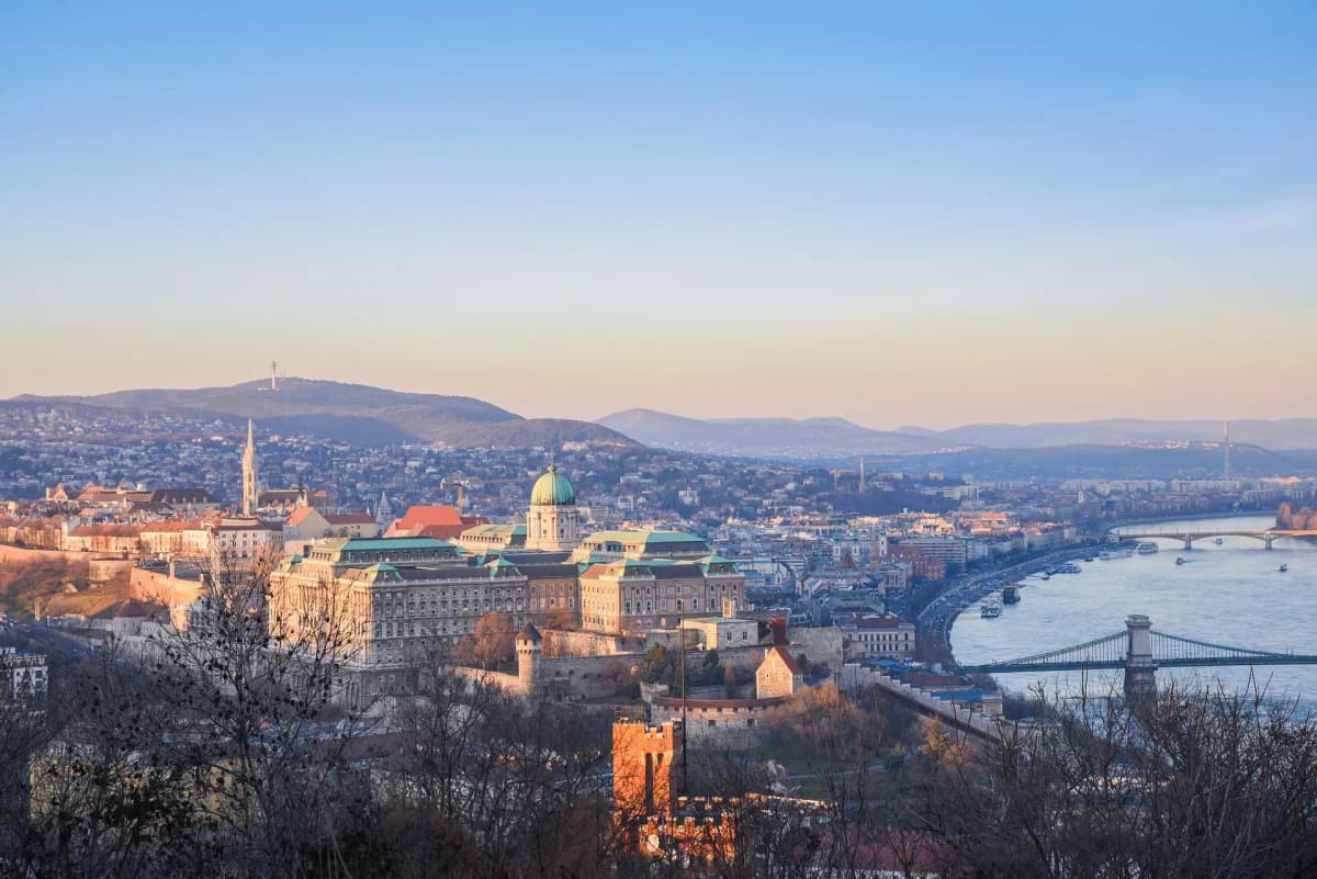DDD Invoices supporting e-invoicing in Hungary, featuring Budapest skyline with historic buildings and the Danube River at sunset.