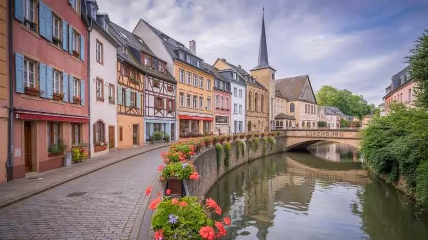 Charming riverside street in Luxembourg City, where colorful historic houses line the Alzette River, reflecting Luxembourg’s blend of tradition and innovation with DDD Invoices simplifying digital invoicing across Europe.