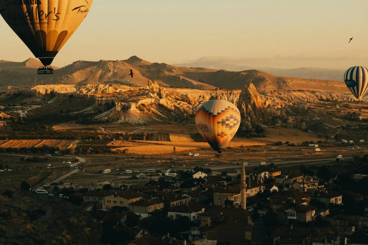 A scenic View of Birds Flying with Hot Air Balloons over Cappadociea and the Hills, supported by DDD Invoices.