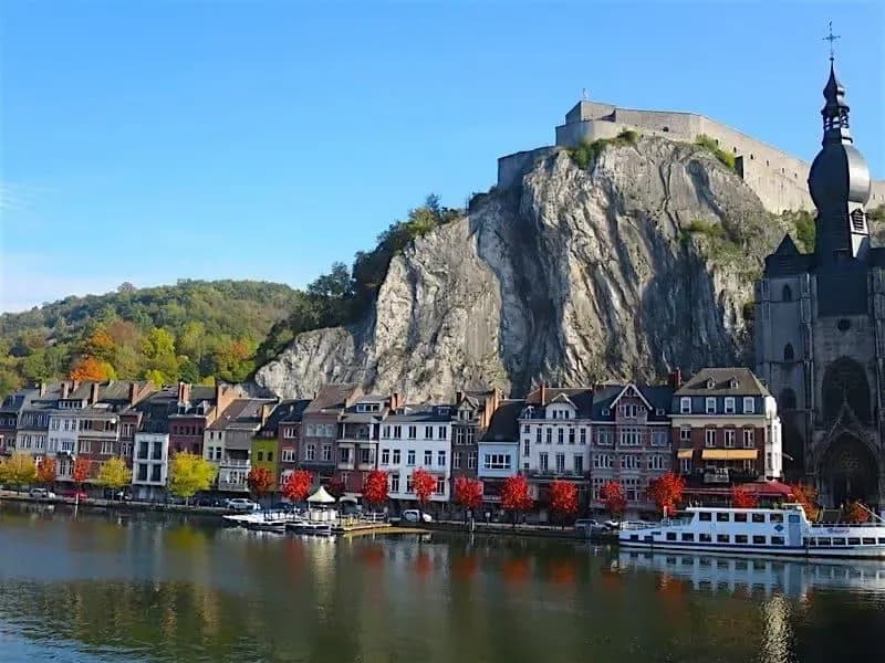 Colorful riverside buildings and the Citadel of Dinant in Belgium, where e-invoicing is becoming mandatory in 2026 with DDD Invoices offering API solution.