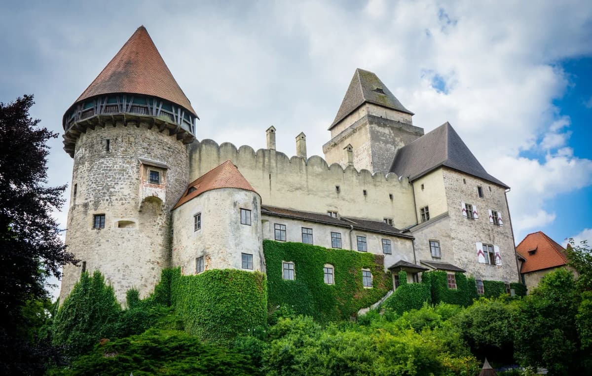 DDD Invoices supporting e-invoicing in Austria, featuring a historic castle surrounded by greenery and medieval architecture.