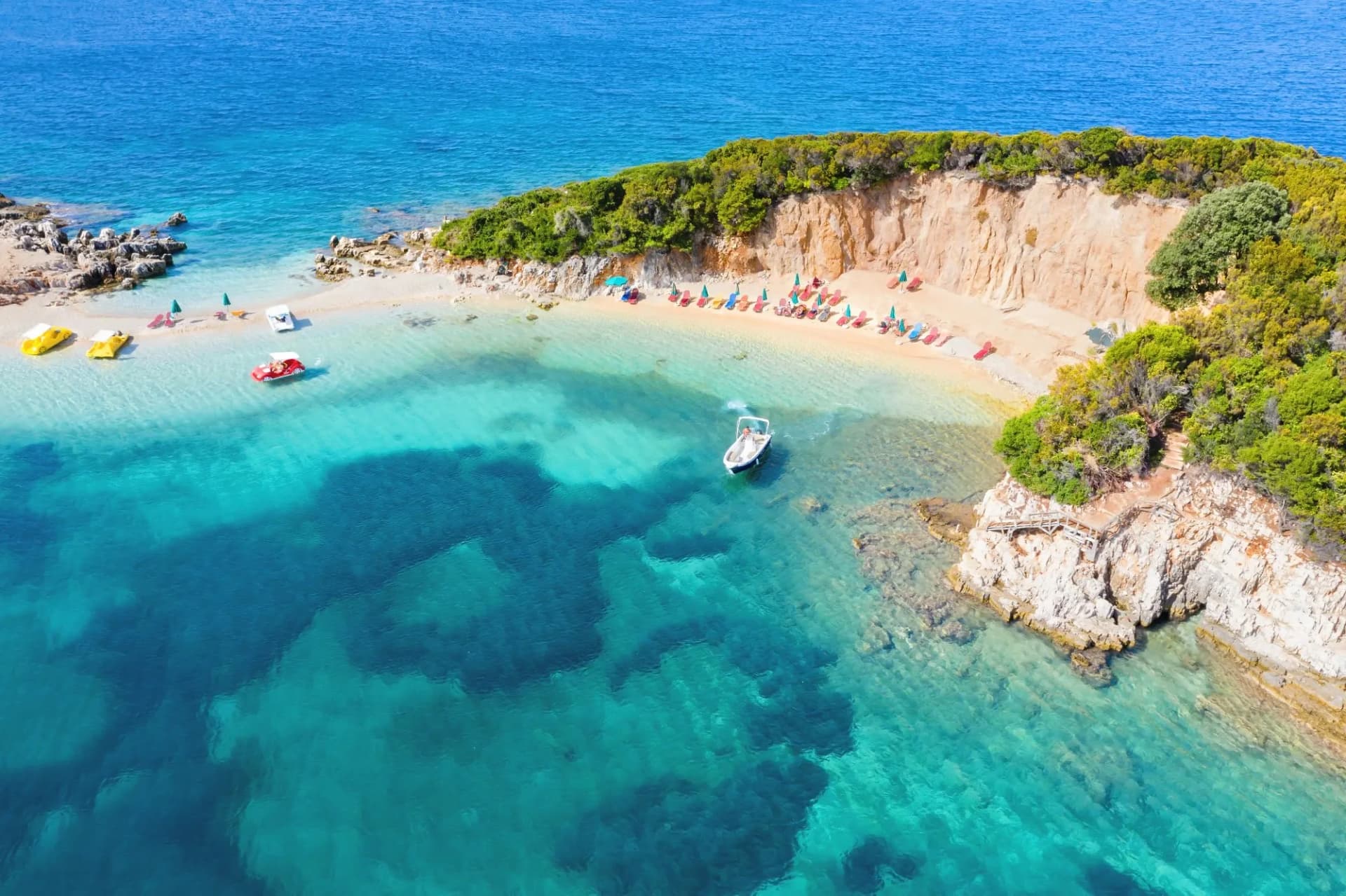 Crystal-clear coastal cove in Albania with boats and a sandy beach, as the country moves toward mandatory e-invoicing supported by DDD Invoices’ API solution.